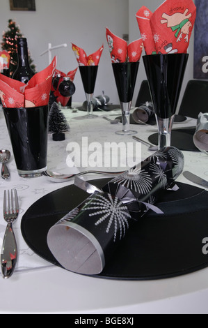 Christmas dinner decorations including a silver christmas cracker on a modern/trendy dining table Stock Photo