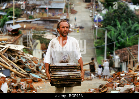 The 1999 earthquake in Colombia was the strongest to strike Colombia for 16 years.  Asurvivor salvages roof tiles from his home Stock Photo