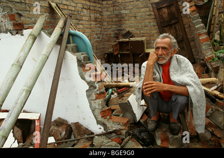 The 1999 earthquake in Colombia was the strongest to strike Colombia for 16 years. A man sits in shock in the ruins of his home Stock Photo