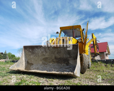 Yellow backhoe loader parked at construction site Stock Photo