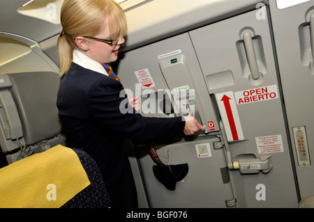 Cabin crew member secures the aircraft door of a commercial airplane flight Stock Photo