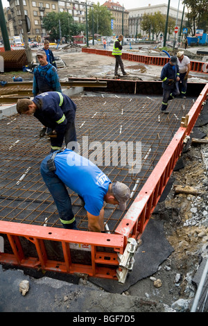 Polish construction workers prepare to lay reinforced concrete for new tram tracks a road site in Krakow town centre. Poland. Stock Photo