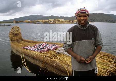 Uros Indian man & traditional boat made of totora reeds. Lake Titicaca. Peru. Uros indians:a pre Incan tribe of native Americans Stock Photo