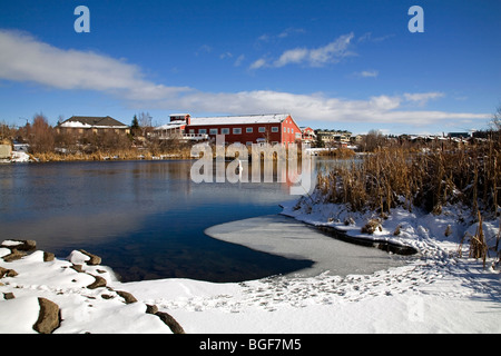 The Deschutes River and the Old Mill Shopping area in Bend, Oregon, after a winter snowfall Stock Photo