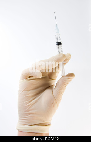 Gloved Hand Holding Hypodermic Needle Syringe Isolated on White Stock Photo