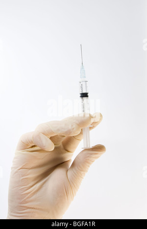 Gloved Hand Holding Hypodermic Needle Syringe Isolated on White Stock Photo