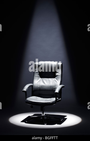 Empty Black Leather Chair under Spotlight Mastermind Stock Photo