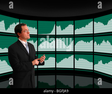Businessman in suit viewing economic data graphs on curved wall screens Stock Photo