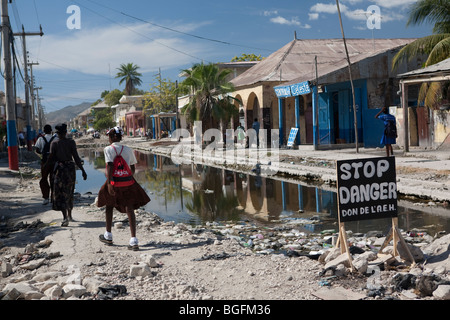 Street scene in Gonaives, Artibonite Department, Haiti, showing an incomplete drainage canal filled with rubbish. Stock Photo