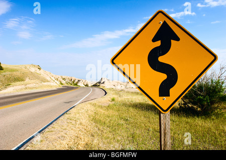 A 'Curves Ahead' sign, beside a road in Badlands National Park, South Dakota. Stock Photo