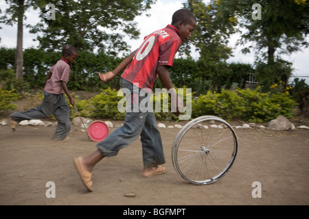 Boys play with wheels in an orphanage in Kilimanjaro Region, Tanzania, East Africa. Stock Photo