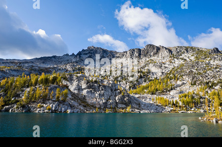 Larch trees changing their colors in Fall on the Enchantment Peaks above Perfection Lake, Enchantment Lakes Stock Photo