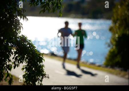 Couple jogging beside Brisbane River Queensland Australia Stock Photo