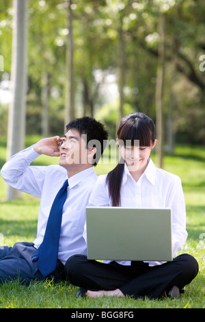 Man and woman on telephone in park Stock Photo