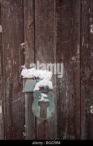snow on an old rusty padlock Stock Photo