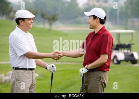 Two golfers shaking hands on the course Stock Photo