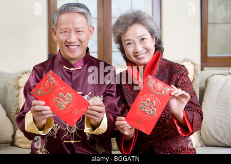 Senior couple holding Chinese new year red envelop Stock Photo