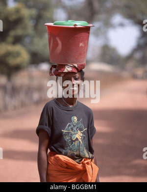 Local village woman carrying bucket on head, Juffure, North Bank Division, Gambia Stock Photo