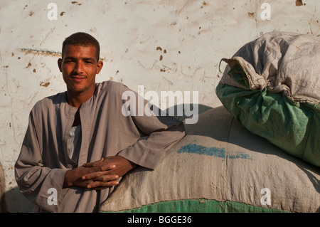 Handsome young Egyptian man preparing to sell grain at a market in the Nile River Valley Stock Photo