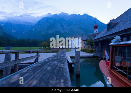 Inn beside a jetty, church and Watzmann in the background, St. Bartholomae, Bavaria, Germany Stock Photo