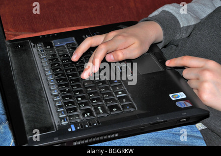 close up of a childs hands on the keyboard of a laptop. Stock Photo