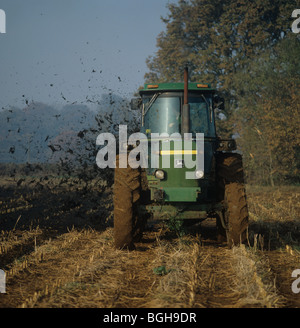 John Deere tractor spreading muck onto maize stubble before cultivation and replanting Stock Photo