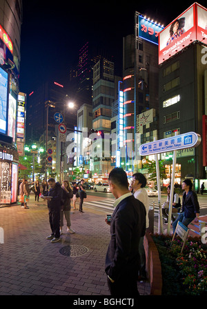 Waiting on a street corner. Neon lit night scene, Roppongi Tokyo, Japan Stock Photo