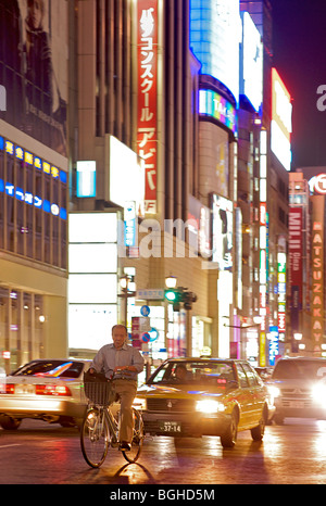 Cyclist and traffic, Ginza, Tokyo at night. Japan Stock Photo