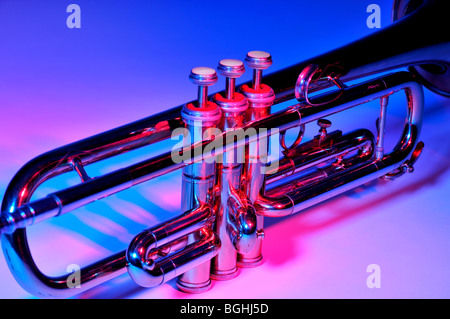 Trumpet under coloured lighting showing valves and tubing. Stock Photo