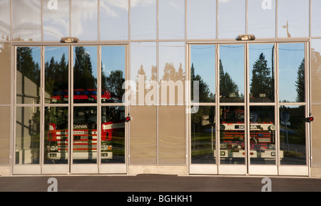 Fire department trucks behind closed garage glass doors , Finland Stock Photo