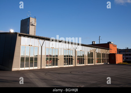 Fire station garage glass doors and parked fire engines inside the building , Finland Stock Photo