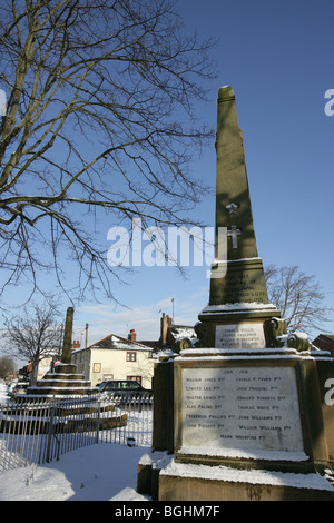 Village of Holt, Wales. First and Second World War memorial in Holt village centre on a cold, snowy winter’s day. Stock Photo