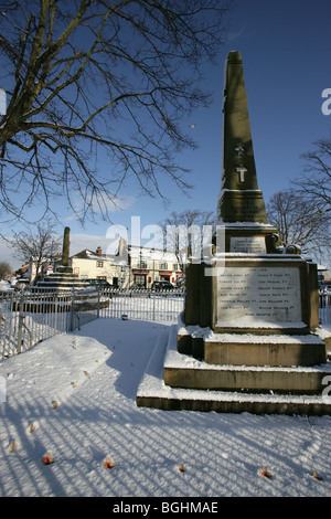 Village of Holt, Wales. First and Second World War memorial in Holt village centre on a cold, snowy winter’s day. Stock Photo