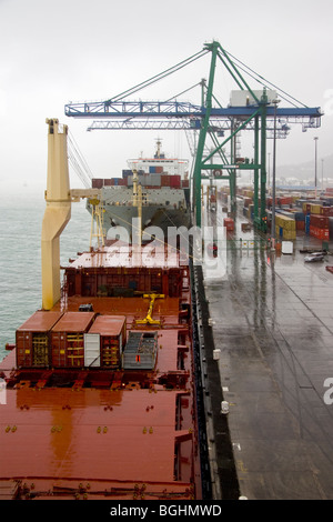 Container ships alongside quay on a rainy day Stock Photo
