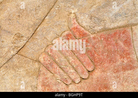 Close up of  carved relief of hand on shoulder on a restored pillar in the open-air Museum at Karnak Temple, Luxor Egypt Stock Photo