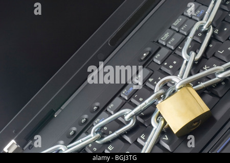 Chain and lock across a keyboard depicting computer security Stock Photo