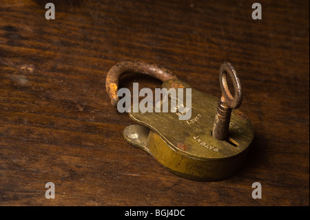Joined key and lock set against a grained wooden background. Stock Photo