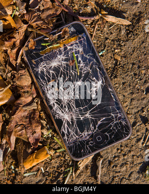 ARLINGTON, VIRGINIA, USA - Damaged Apple iPhone 3G smart phone, with shattered screen, in street gutter. Stock Photo