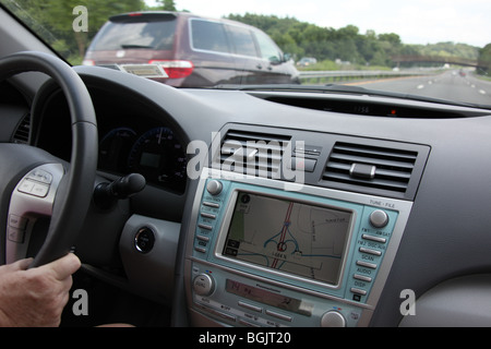 Driver uses car GPS system to navigate the roadways. Stock Photo