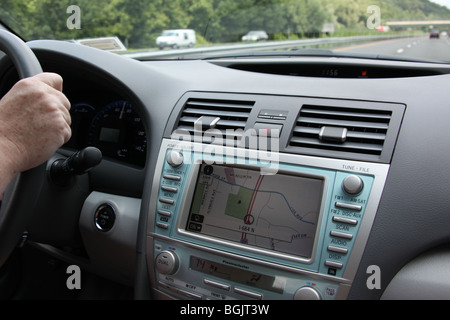 Driver uses car GPS system to navigate the roadways. Stock Photo