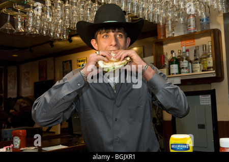 Professional Bull Riders' J. B. Mauney, the 2009 World Champ runner up eats the PBR Bull Bucking Hero sandwich at the Stage Deli Stock Photo