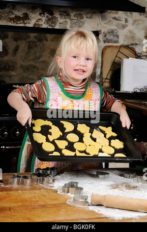 Stock photo of a four year old girl making cookies in the kitchen. Stock Photo
