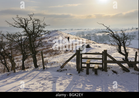 Walker in the Winter snow on the Shropshire Hills, seen from Hope Bowdler Hill, near Church Stretton, January 2010. Stock Photo
