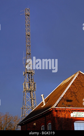 A telecommunications mast above a pointed roof Stock Photo