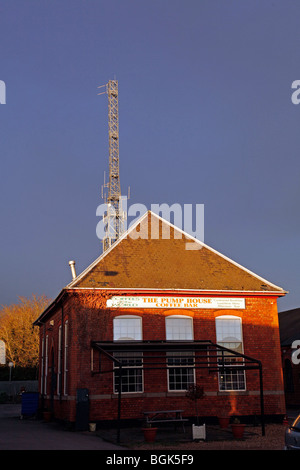 A telecommunications mast above a pointed roof Stock Photo