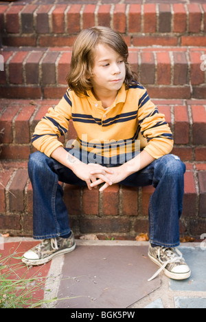 boy sitting on steps Stock Photo