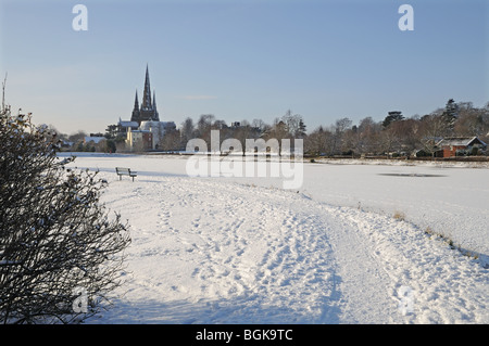 Three spires Cathedral and frozen Stowe Pool on snowy winter’s day 2010 Lichfield England Stock Photo