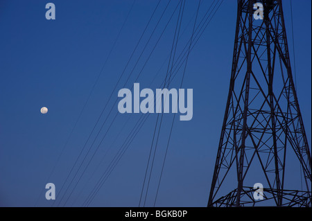 Electricity pylons and full moon Stock Photo