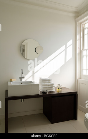 Modern bathroom with black washstand and round mirror Stock Photo