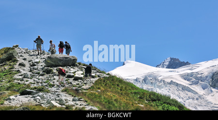 Mountain walkers walking along path towards the Swiss Moiry Glacier, Pennine Alps / Walliser Alpen, Valais / Wallis, Switzerland Stock Photo